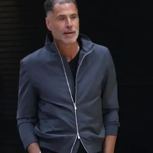 Rob Pelinka wearing a Los Angeles Lakers jacket during a media availability, featuring team branding, zip-up front, and tailored sporty design.