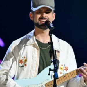 Alex Brown wearing a cropped jacket on The Voice Season 28, featuring a modern short-length cut, front zip closure, and stylish contemporary design.